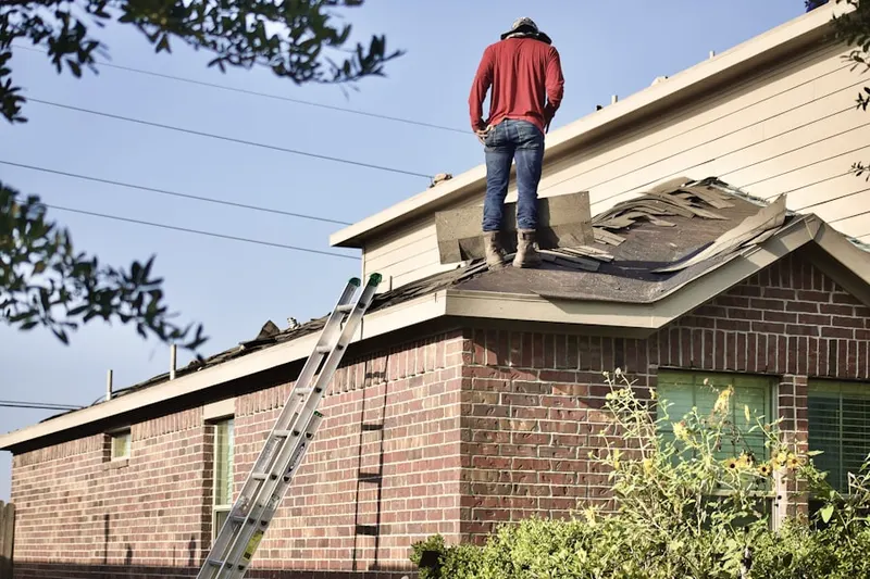 Professional roofer working on a residential roof in Alegre